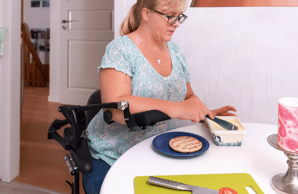 Woman butters bread using her O110 arm support